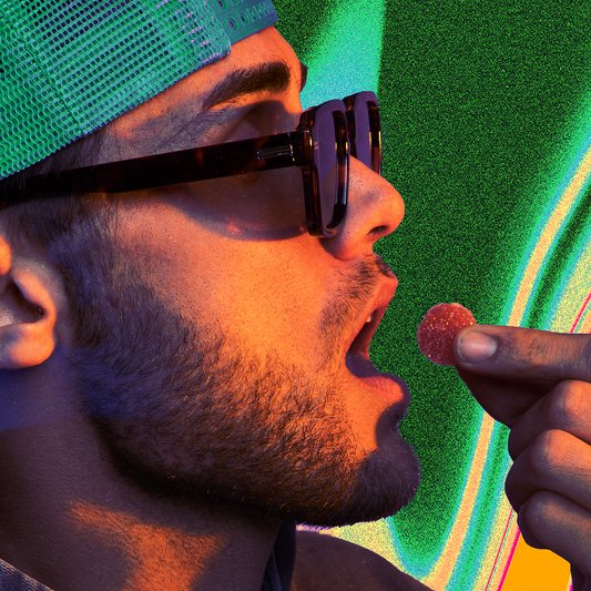 Man in green mesh cap and sunglasses about to eat a red sugar-coated gummy