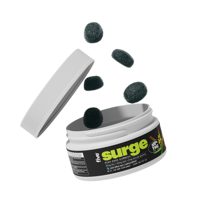 Open jar labeled "the surge" with a THC badge; dark sugar-coated gummies tumbling from the container